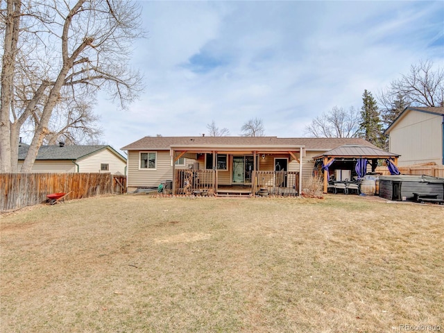 back of house with a gazebo, fence, and a lawn