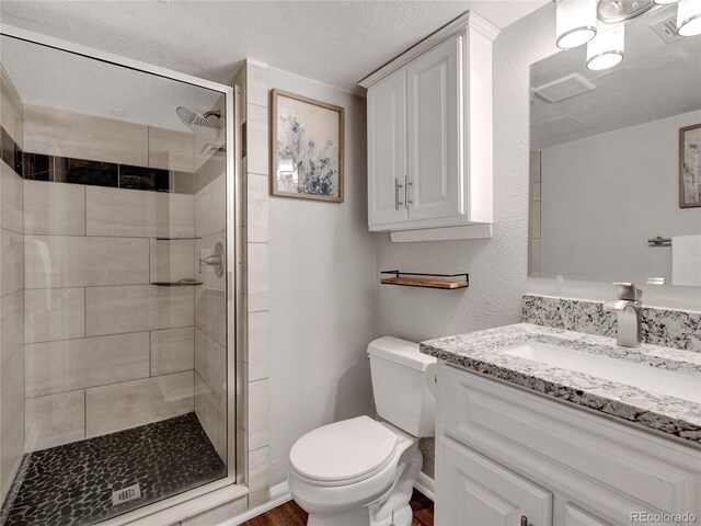 6523 S Field Way, Littleton, CO 80123 - full bath with vanity, toilet, a shower stall, a textured ceiling, and wood finished floors
