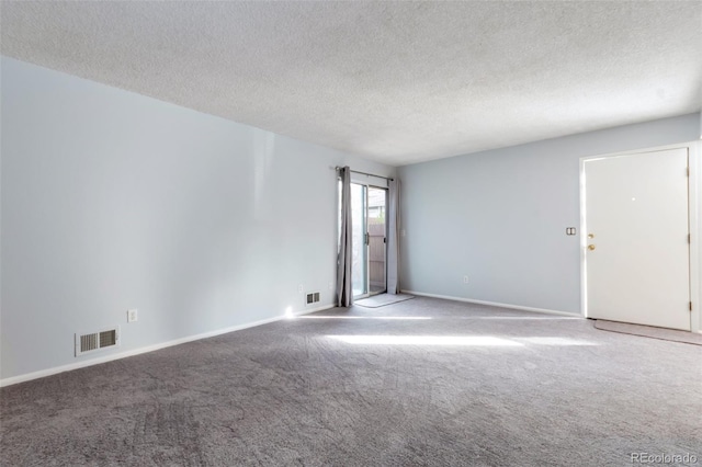 carpeted spare room featuring a textured ceiling