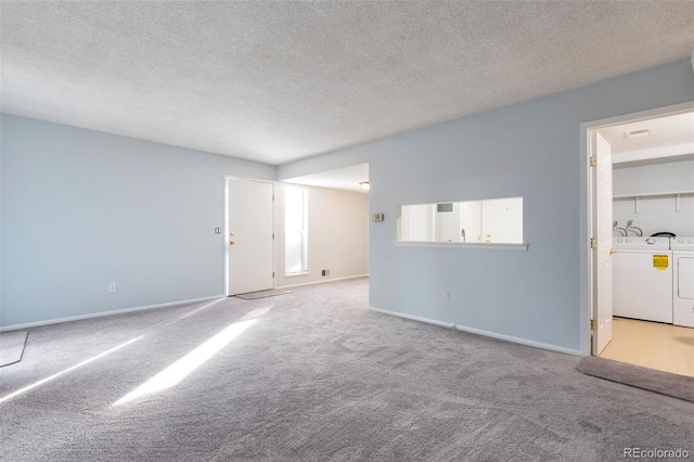 carpeted empty room featuring washing machine and dryer and a textured ceiling