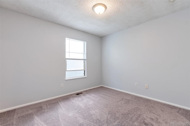 carpeted spare room featuring a textured ceiling