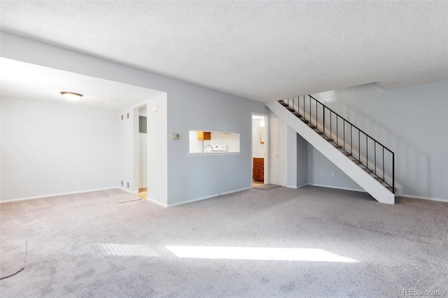 unfurnished living room featuring carpet and a textured ceiling