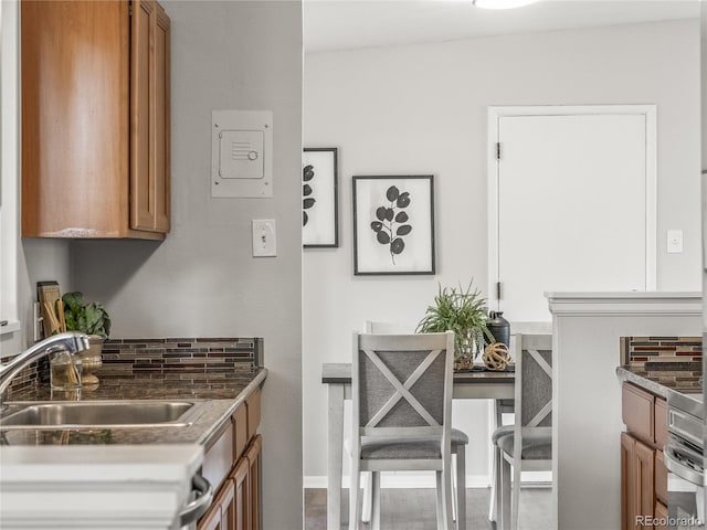 5995 Estes St, Arvada, CO 80004 - kitchen with a sink, brown cabinetry, and baseboards
