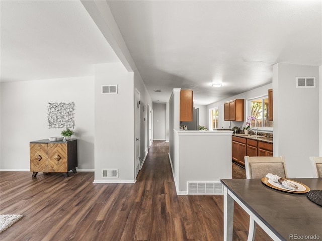 5995 Estes St, Arvada, CO 80004 - kitchen featuring dark wood finished floors, brown cabinetry, open floor plan, and a sink