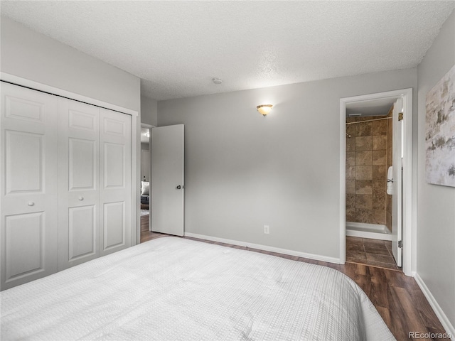 5995 Estes St, Arvada, CO 80004 - bedroom with a closet, wood finished floors, a textured ceiling, baseboards, and ensuite bathroom