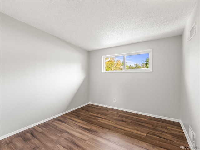 5995 Estes St, Arvada, CO 80004 - spare room featuring dark wood finished floors, a textured ceiling, and baseboards