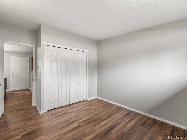 5995 Estes St, Arvada, CO 80004 - unfurnished bedroom with wood finished floors, baseboards, a closet, and a textured ceiling