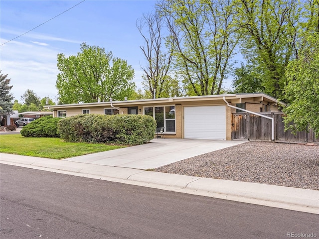 5995 Estes St, Arvada, CO 80004 - view of front facade with a garage, concrete driveway, and brick siding