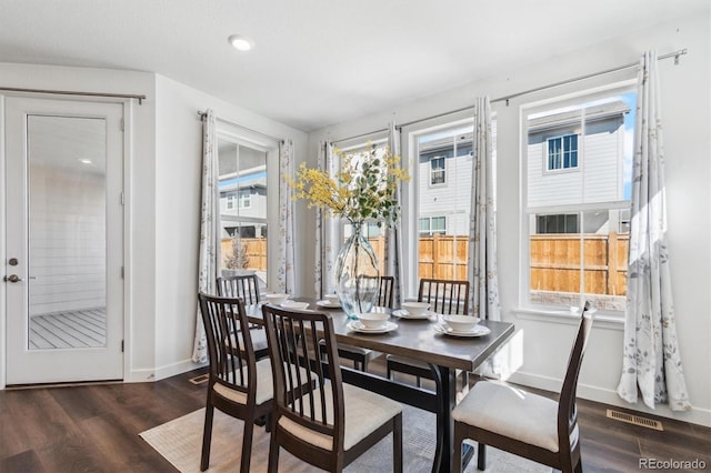 dining space featuring a healthy amount of sunlight, baseboards, visible vents, and wood finished floors