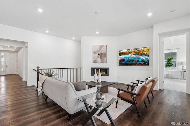 living area featuring dark wood-type flooring, a glass covered fireplace, a wealth of natural light, and recessed lighting