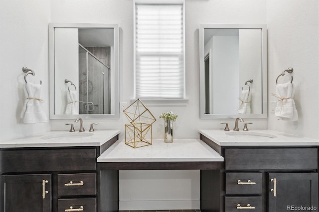 full bath with a stall shower, two vanities, and a sink