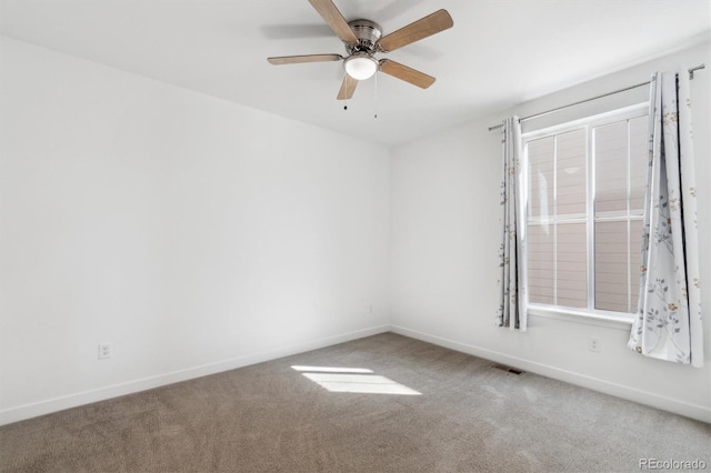 carpeted spare room featuring visible vents, ceiling fan, and baseboards