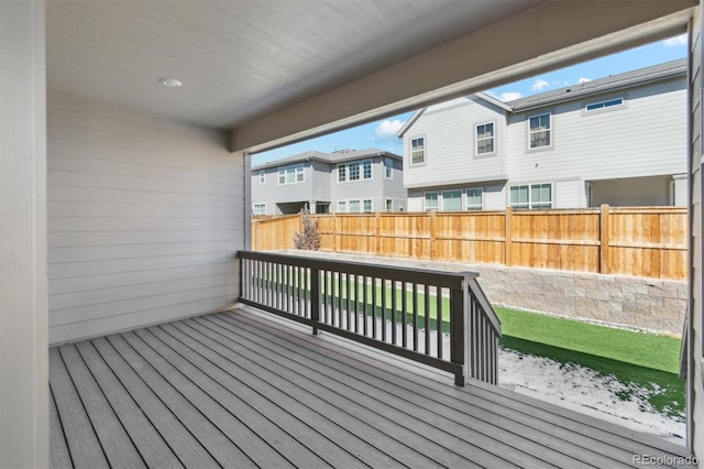 wooden terrace featuring a residential view and fence