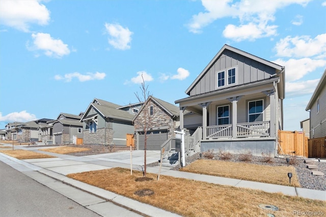 view of front of home featuring driveway, a residential view, fence, a porch, and board and batten siding