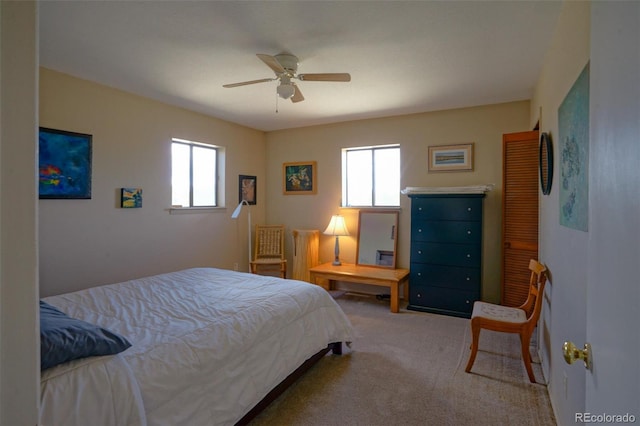 carpeted bedroom featuring ceiling fan and multiple windows
