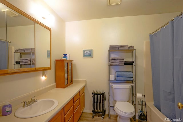 full bathroom featuring radiator heating unit, toilet, vanity, and shower / bath combo