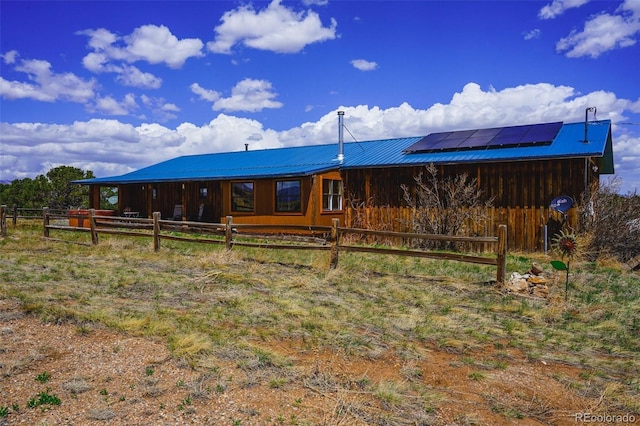 back of property featuring metal roof, an outdoor structure, and an exterior structure