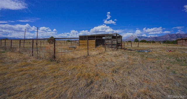 exterior space featuring a mountain view, an exterior structure, an outdoor structure, and a rural view