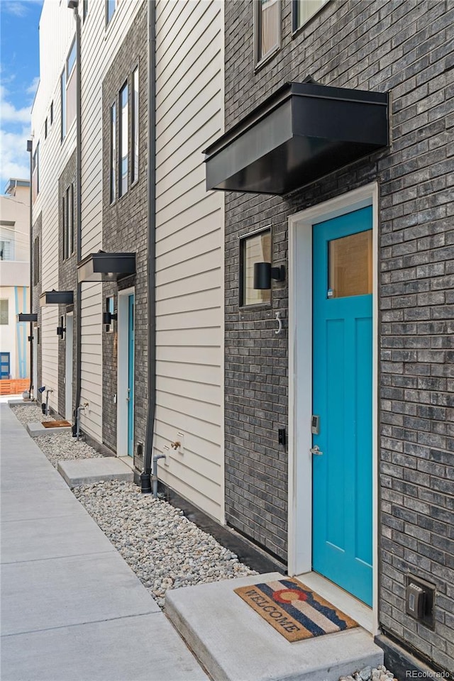 property entrance featuring a residential view and brick siding