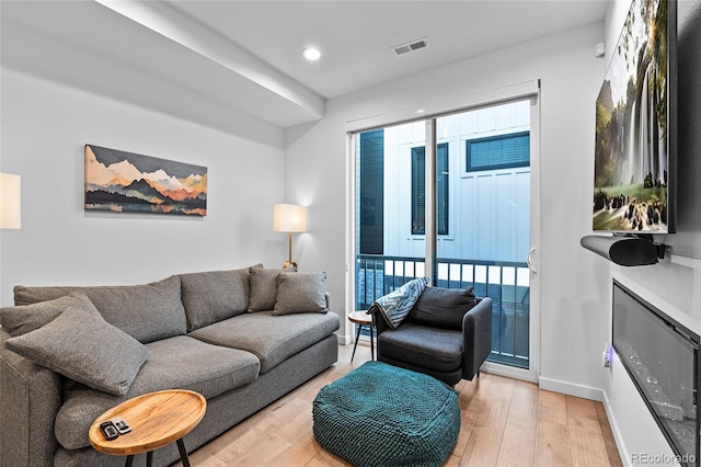 living room featuring light wood-style flooring, visible vents, baseboards, and recessed lighting