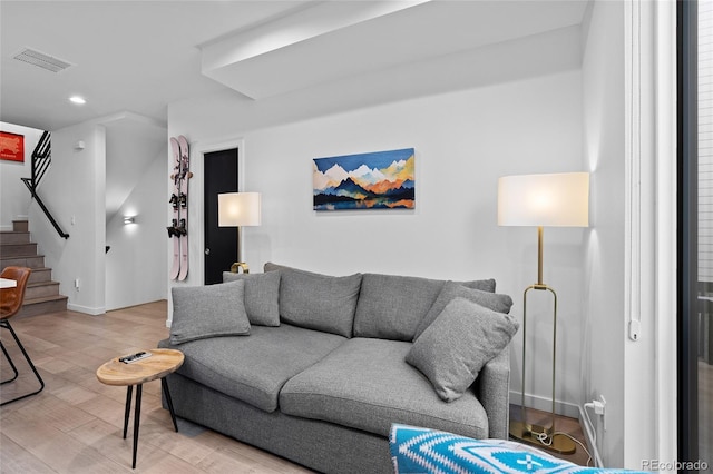 living room featuring recessed lighting, wood finished floors, visible vents, baseboards, and stairs