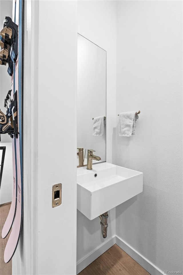 bathroom featuring a sink, baseboards, and wood finished floors