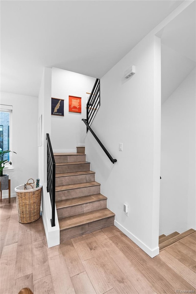 staircase with wood finished floors and baseboards