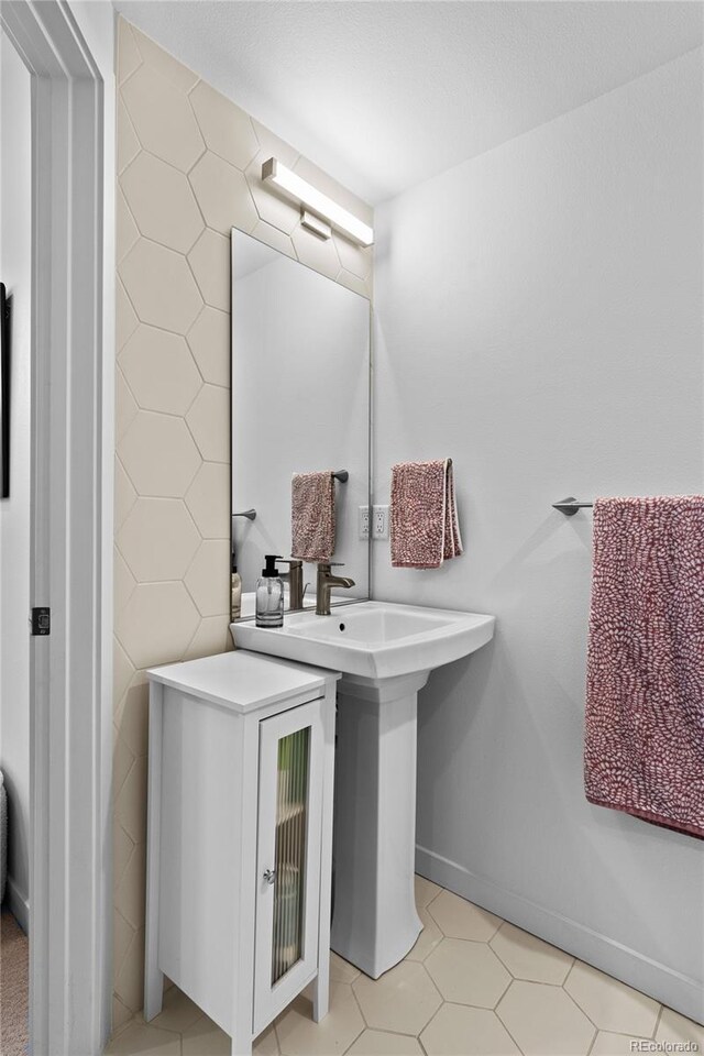 bathroom with baseboards and tile walls