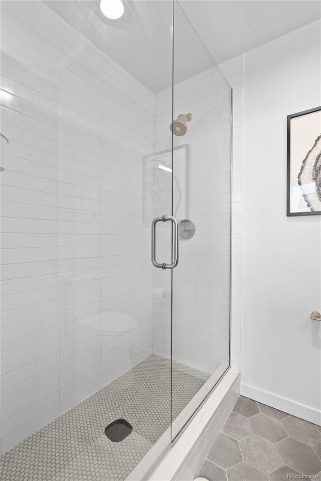 bathroom with a stall shower and baseboards