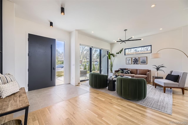 living room featuring an inviting chandelier, light wood-style floors, and recessed lighting