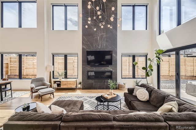 living area featuring plenty of natural light, wood finished floors, and a towering ceiling
