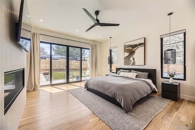bedroom featuring light wood finished floors, recessed lighting, baseboards, and access to exterior