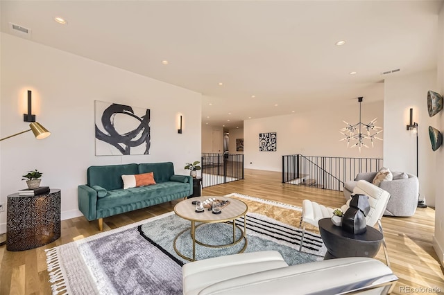 living room with light wood-type flooring, recessed lighting, and visible vents