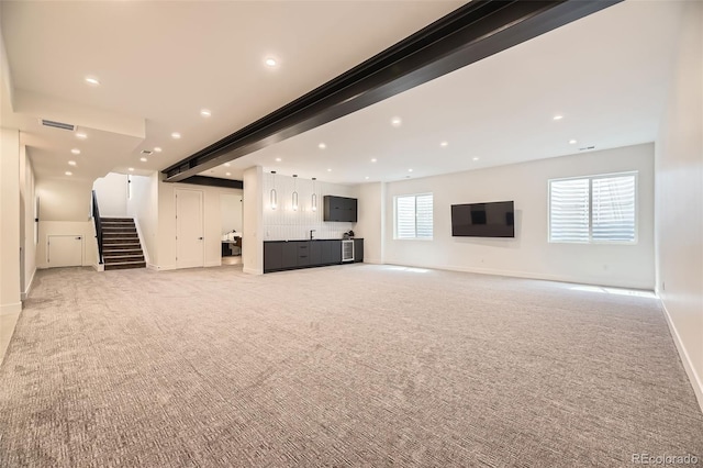 unfurnished living room with baseboards, stairway, recessed lighting, and light colored carpet