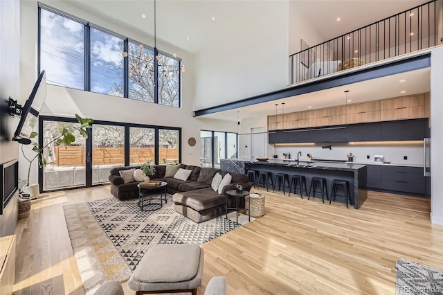 living area featuring light wood-style floors and a high ceiling