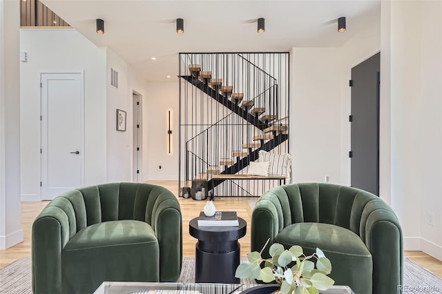 interior space featuring visible vents, wood finished floors, baseboards, and stairs
