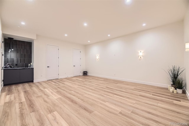 unfurnished room featuring baseboards, recessed lighting, and light wood-type flooring