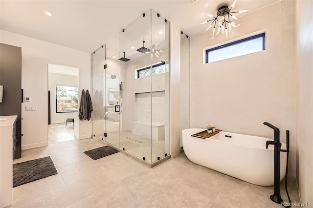bathroom with a stall shower, a wealth of natural light, a soaking tub, and vanity