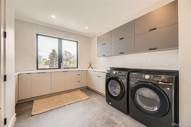 clothes washing area featuring recessed lighting, cabinet space, and washer and dryer