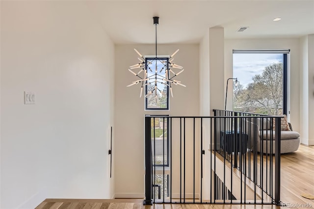 details featuring a notable chandelier, baseboards, visible vents, and wood finished floors