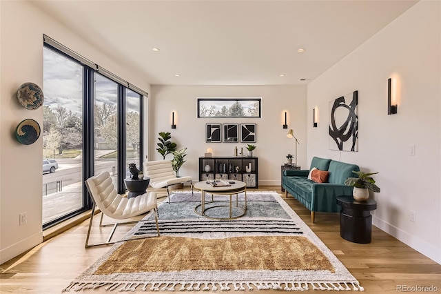 living area featuring baseboards, light wood finished floors, and recessed lighting