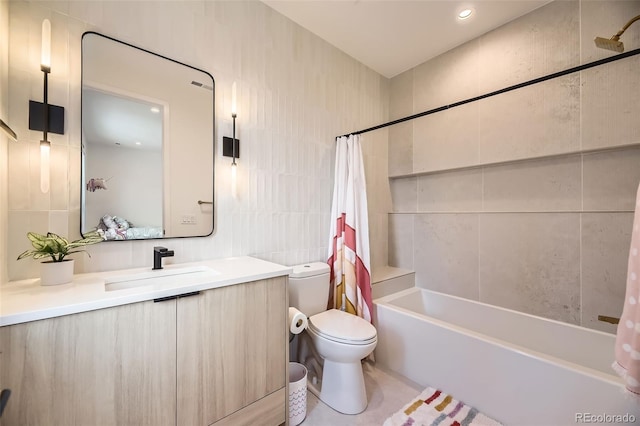 bathroom with vanity, tile walls, shower / tub combo, and toilet