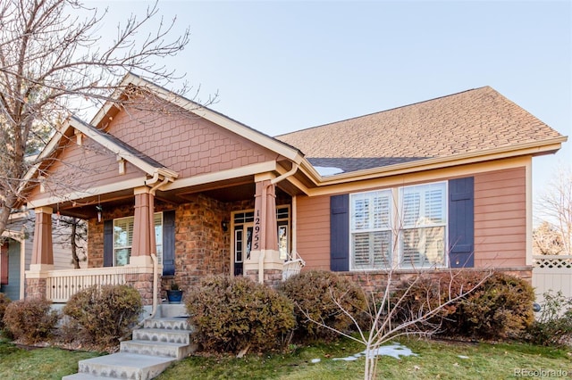 12955 Vallejo Cir, Westminster, CO 80234 - view of front of home with a porch, stone siding, and roof with shingles