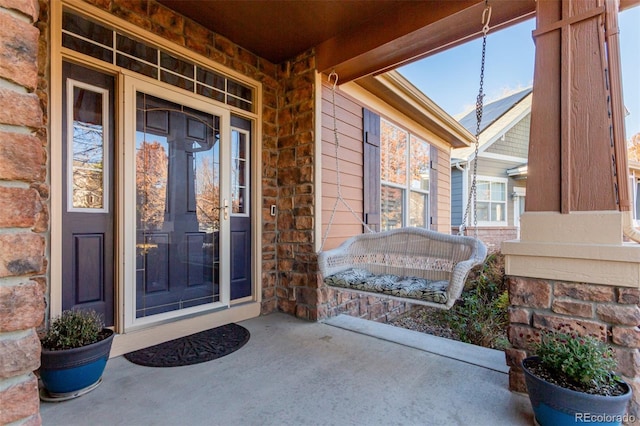 12955 Vallejo Cir, Westminster, CO 80234 - doorway to property featuring covered porch and stone siding