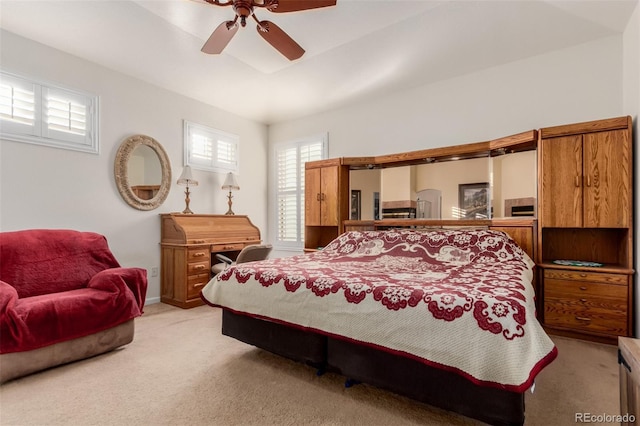 carpeted bedroom featuring multiple windows and ceiling fan