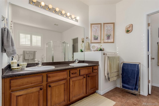 bathroom featuring tile patterned flooring, vanity, and walk in shower