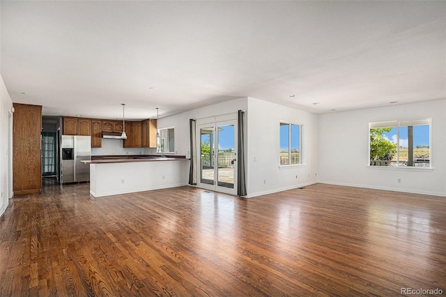 unfurnished living room featuring dark wood finished floors and baseboards