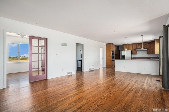 unfurnished living room featuring sink and wood-type flooring