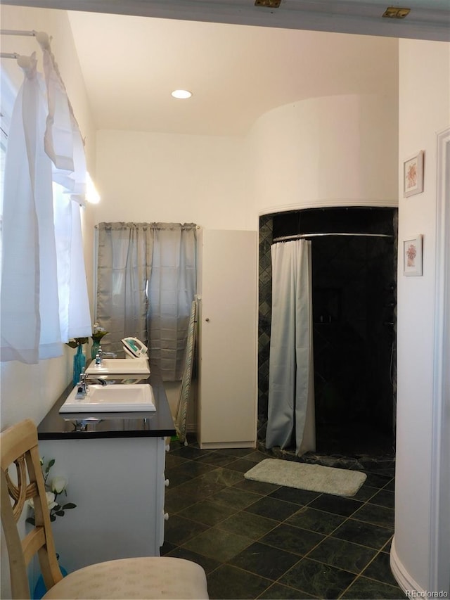 bathroom featuring double vanity and a shower with shower curtain