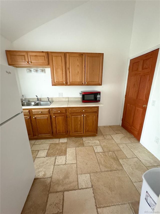 kitchen with sink, high vaulted ceiling, light tile patterned floors, and white fridge